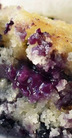 a close up of a piece of cake with blueberries on it and crumbs