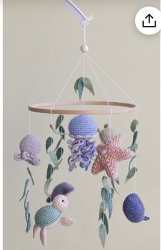 a crocheted sea animal mobile hanging from a ceiling