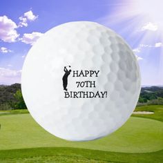 a golf ball with the words happy 70th on it in front of a green field