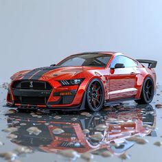 a red sports car with black stripes parked in front of some rocks and pebbles on the ground