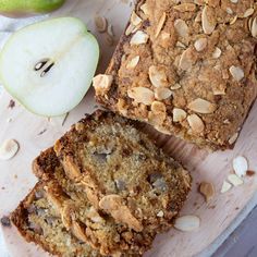 an apple and oatmeal bread on a cutting board next to sliced apples