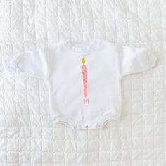 "This first birthday design includes a pink candle and is available in 8 different product types. It can read \"one\" as shown in the pictures, or alternatively, it can feature your little one's name in the personalization section. The design is printed on 100% cotton on either a short sleeve bodysuit, long sleeve bodysuit, sweatshirt romper, sleeper, or toddler sweatshirt, long sleeve, or short sleeve. This piece is a sturdy material, cozy soft and perfect for staying cuddly. Perfect for your babe's bday celebration. Sizing: long and short sleeves: true to size sweatshirt romper and sweatshirt: oversized sleeper: fits large sweatshirt: slightly oversized but more true to size This product is handprinted using nontoxic, water-based inks on a cotton sweatshirt material romper with three sna Pink Long Sleeve Top For Birthday, Personalized Pink Top For First Birthday, Personalized Pink Tops For First Birthday, Custom Pink Tops For First Birthday, Birthday Pjs, Cupcake Shirt, Birthday Romper, Candle Girl, Sweatshirt Romper