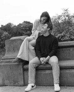 black and white photograph of two people sitting on a bench