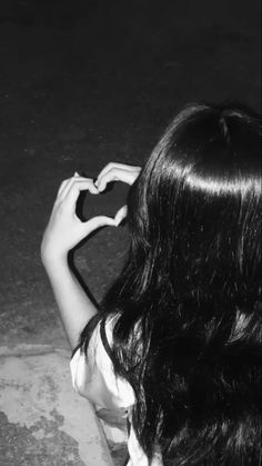 black and white photograph of a woman holding a heart shaped object