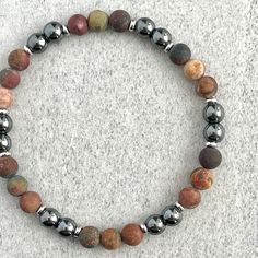 Men's beaded bracelet features: ~ 6mm, 8mm or 10mm Matte Picasso Jasper beads ~ 6mm, 8mm or 10mm Hematite beads ~ 4mm, 6mm or 8mm stainless steel spacers ~ Strong, non-fraying elastic cord; simply slide bracelet on and off wrist ~ Comes packaged in a re-usable micro fibre pouch To ensure the perfect fit, please use the bracelet sizing instructions found in the photo gallery. Slide Bracelet, Hematite Bracelet, Picasso Jasper, Mens Beaded Bracelets, Hematite Beads, Bead Bracelets, New Bands, Jasper Beads, Stretch Bracelets