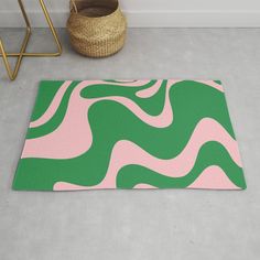 a green and pink area rug on the floor next to a basket with a plant