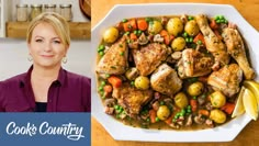 a woman sitting in front of a white plate filled with chicken, potatoes and peas