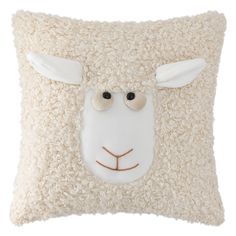 a white sheep pillow with black eyes