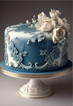 a blue and white cake with flowers on top