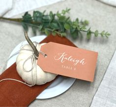 a white pumpkin sitting on top of a plate next to a tag that says, thank you