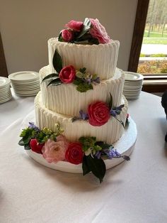 a three tiered wedding cake with flowers on it