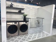 a washer and dryer are on display in a showroom with tile flooring