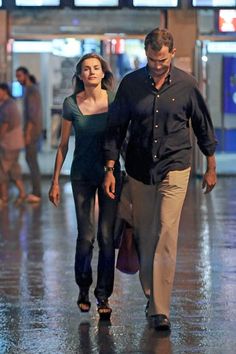 a man and woman are walking down the street