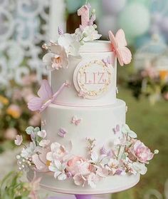 a wedding cake decorated with flowers and butterflies