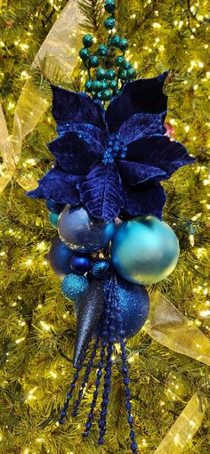 a blue christmas ornament hanging from a tree