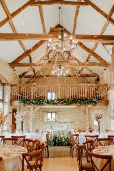 the inside of a wedding venue with chandeliers hanging from the ceiling and tables covered in white linens