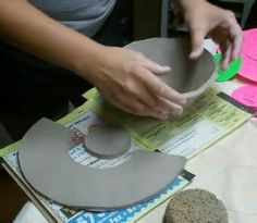 a person is working on some paper with scissors and other crafting supplies around them