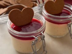 two small jars filled with pudding and heart shaped cookies on top of each other,