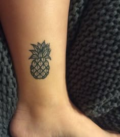 a small pineapple tattoo on the ankle