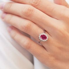 Deep red coloured ruby is famous for its protective power which bring happiness and passion - that's why it makes best gift for a loved ones for Valentine’s Day or an anniversary. Ruby's hue is close to the color of blood, which carries oxygen, the gemstone also represents vitality and vigor.  #klenota #klenotajewelry #klenotaring #whitegold #14k #14carat #engagement #engagementrings #gemstonering #rubyring #diamond-rings #bigstone #halorings #ringsforher #bridetobe #jewelrymakers #classicstyle Oval Ruby Halo Ring With Brilliant Cut, Oval Red Diamond Ring With Halo Setting, Oval Ruby Halo Ring, Classic Red Halo Ring, Red Oval Cluster Ring With Halo Design, Elegant Oval Red Halo Ring, Ruby Ring With Halo Setting For Proposal, Red Diamond Wedding Ring With Halo, Elegant Halo Ring With Lab-created Ruby