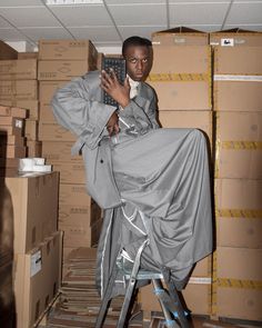 a man sitting on top of a step stool holding a remote control in his hand