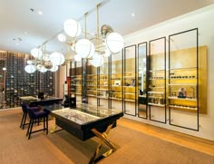 a room filled with lots of tables and chairs next to a wall covered in wine bottles