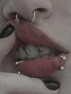 a woman with piercings on her teeth