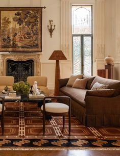 a living room with couches, chairs and a table in front of a fireplace