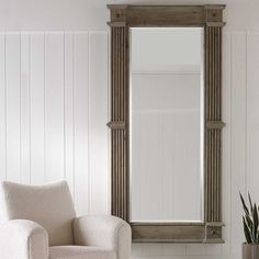 a chair and mirror in a room with white walls