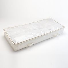 an empty white suitcase sitting on top of a white tablecloth covered floor with handles