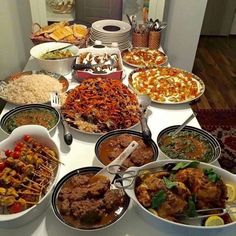 a table filled with lots of different types of food on top of plates and bowls