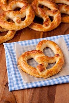 two pretzels sitting on top of a blue and white checkered napkin next to some pretzels