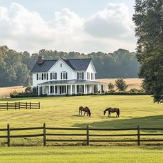 two horses grazing in front of a large white house