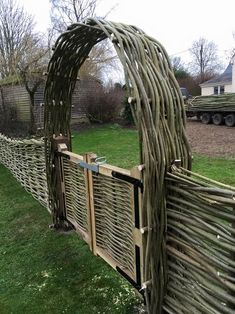 a wooden fence made out of branches in the grass