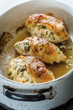 three pieces of chicken cooking in a pan