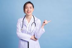 a woman in a white lab coat pointing at something with her hand on the side