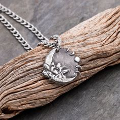 This is a silver necklace featuring a moon with a lotus on one side and waning/waxing moons on the other. We use moldable silver which we shape into our designs. After firing at 1200F it is 99.9% pure silver. This pendant is compared to a penny in the picture for you to get a sense of its size. Please see our video also which features the product up close! We offer multiple stainless steel chain sizes that go with this pendant in the options. We sell real silver chains separately. Please message Moon Phases Necklace, Stainless Steel Chain, Pure Silver, Fine Silver, Lotus, Silver Necklaces, Silver Chain, Charm Necklace, Silver Necklace