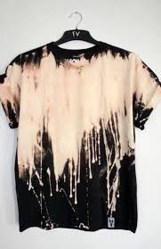 a black and white tie dye t - shirt hanging on a hanger