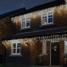 a house is decorated with christmas lights and wreaths