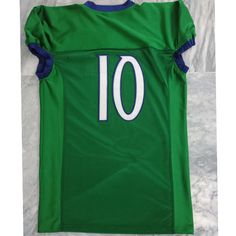 a green jersey with the number 10 on it is laying on a white surface in front of a marble floor