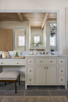 a large bathroom with two sinks and a stool in front of the mirror on the wall