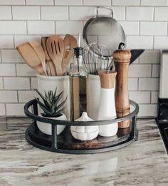 kitchen utensils and wooden spoons are arranged in a holder on the counter