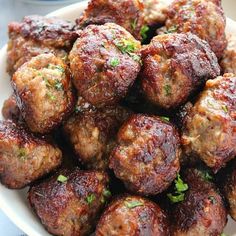 a white plate topped with meatballs covered in sauce