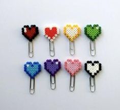 six different colored heart shaped clips on a white surface