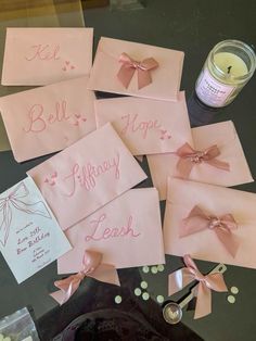 pink cards with bows and writing on them are next to a jar of teas