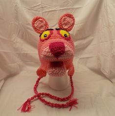 a crocheted pink hat with ears and eyes