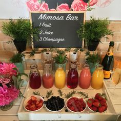 a table topped with lots of different types of drinks and fruit on top of it