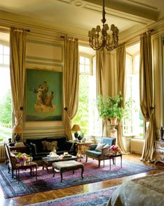 a living room filled with lots of furniture next to a large painting on the wall