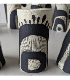 several black and white vases with designs on them