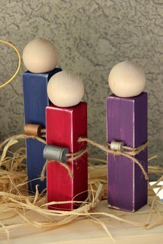 three wooden pegs are sitting on top of hay